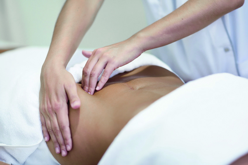 Woman receiving a belly massage at spa salon
